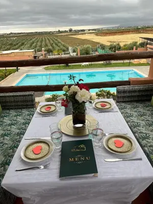 a table with a white table cloth and a pool at Ferme Tynass - Paris Room With Balcony Fes