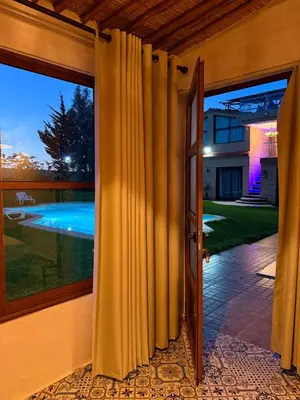 an open door of a house with a swimming pool at Tynass Ferme - Walili Room Fez