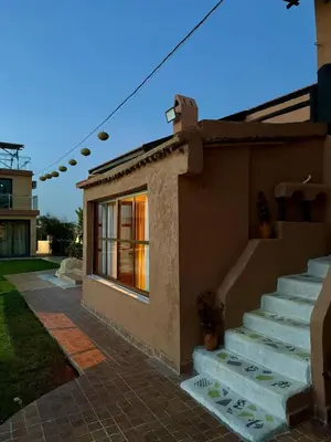 a house with stairs leading up to a window at Tynass Ferme - Walili Room Fez