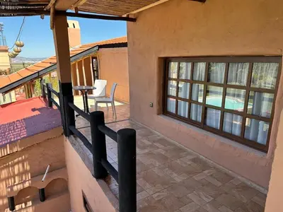 a balcony of a house with a table and a patio at Ferme Tynass - Tynass Suite - Spacious Suite in Tynass Farm