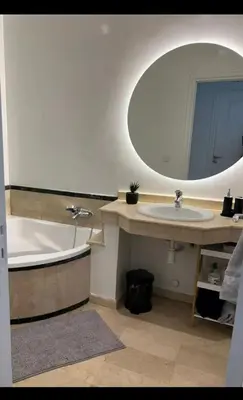 a bathroom with a tub and a sink and a mirror at Mandela in Oulad Akkou