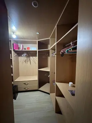 a walk in closet with wooden cabinets and shelves at Spacious and comfortable villa for holidays in Oulad Akkou