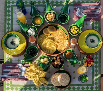 a table with plates of food and bowls of food at Atlas Aura Hotel Ourika - Marrakech