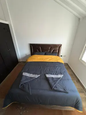 a bedroom with a bed with a blue comforter at Chalet cosy familial à Imouzzer - calme, nature et confort in Imouzzer Kandar