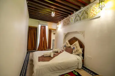 a bedroom with a large bed in a room at Dar Rass Jnane in Fès