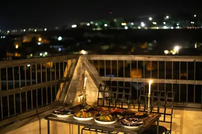 a table with plates of food on a balcony at night at Dar Rass Jnane in Fès