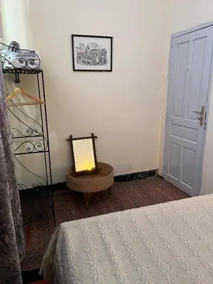a room with a bed and a lamp on a table at Rooftop del quinto in Oulad Akkou