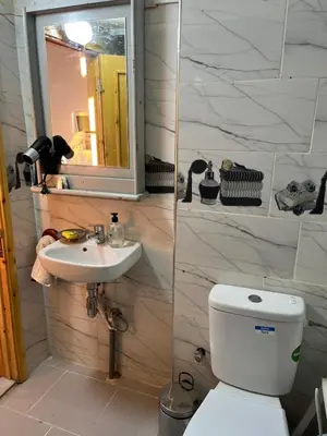 a bathroom with a toilet and a sink and a mirror at Rooftop del quinto in Oulad Akkou