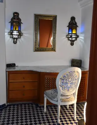 a room with a vanity with a chair and a mirror at Chambre SAPHIR - Riad Lotus Bleu in Fès