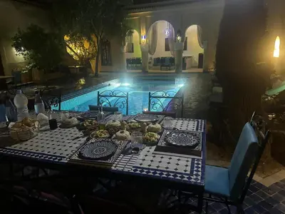 a table with food on it next to a pool at Chambre SAPHIR - Riad Lotus Bleu in Fès