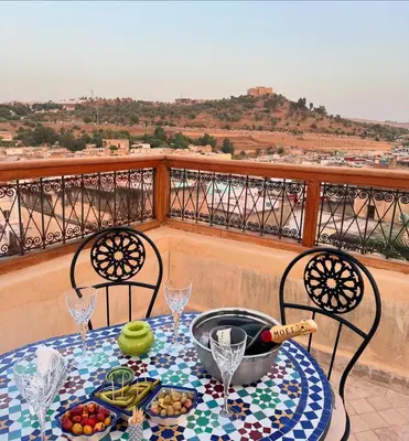a table with a bowl of food on a balcony at Chambre SAPHIR - Riad Lotus Bleu in Fès