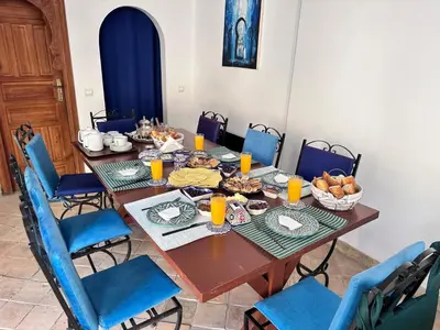 a table with food on it with blue chairs at Chambre SAPHIR - Riad Lotus Bleu in Fès