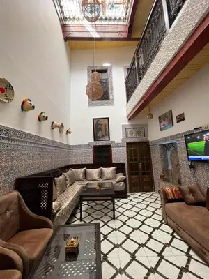 a living room with a couch and a tv at Dar Bab Boujloud Fez in Fès