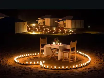 a table with chairs in a circle of lights at Merzouga Joy Camp in Hassilabied