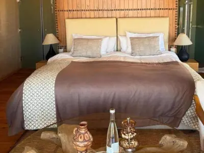 a bedroom with a large bed and a table at Merzouga Joy Camp in Hassilabied