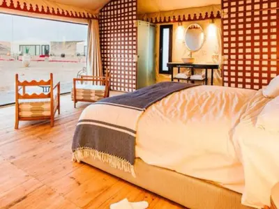 a bedroom with a large bed and a large window at Merzouga Joy Camp in Hassilabied