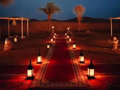 a row of lights in the desert at night at Merzouga Joy Camp in Hassilabied