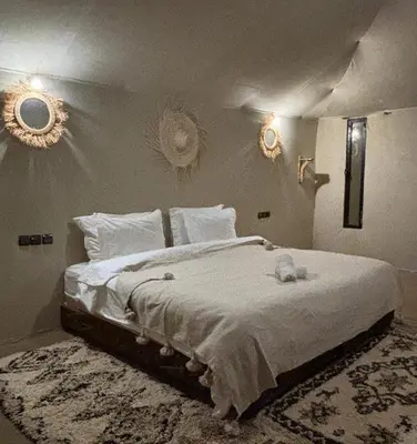 a bedroom with a bed with a teddy bear on it at Golden dunes luxury camp in Merzouga