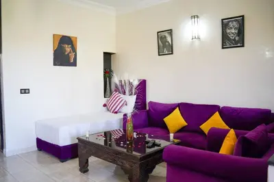 a living room with a purple couch and a coffee table at Eden villa Marrakech in Douar bel Rhanodour