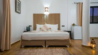 a bedroom with a large bed with a wooden headboard at Eden villa Marrakech in Douar bel Rhanodour