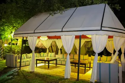 a gazebo with white curtains and a table at Eden villa Marrakech in Douar bel Rhanodour