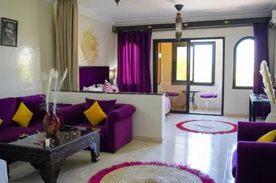 a living room with purple furniture and purple curtains at Eden villa Marrakech in Douar bel Rhanodour