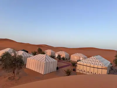 a group of buildings in the desert at Oasis Merzouga Retreat in Merzouga