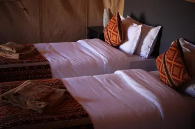 two beds sitting next to each other in a room at Oasis Merzouga Retreat in Merzouga