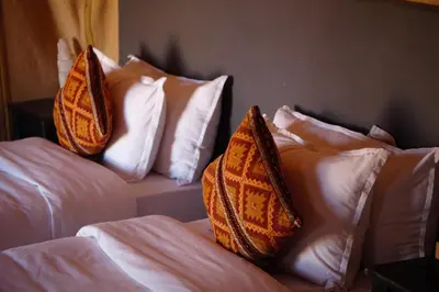 two beds with pillows on them in a room at Oasis Merzouga Retreat in Merzouga