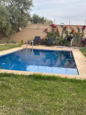 a swimming pool in the grass next to a house at Oasis de Calme Villa Piscine Hammam & Vues Atlas in Ouled el guerne
