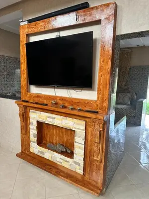 a entertainment center with a tv on top of a fireplace at Oasis de Calme Villa Piscine Hammam & Vues Atlas in Ouled el guerne