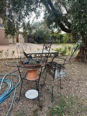 two chairs and a table and a bench in a yard at Oasis de Calme Villa Piscine Hammam & Vues Atlas in Ouled el guerne