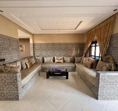 a living room with a large couch and a table at Oasis de Calme Villa Piscine Hammam & Vues Atlas in Ouled el guerne