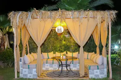 a gazebo with a table and a yellow couch at Villa Eden Marrakech - Luxury Spa Events in Douar bel Rhanodour
