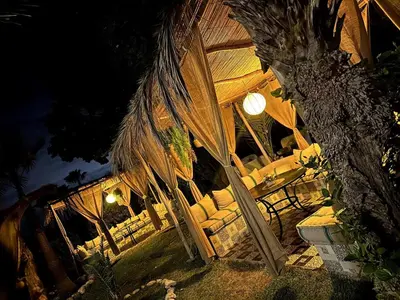a building with an umbrella and chairs in front of it at night at Villa Eden Marrakech - Luxury Spa Events in Douar bel Rhanodour