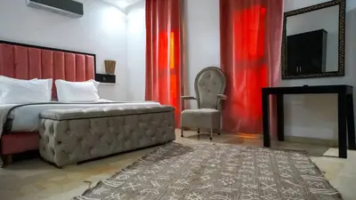 a bedroom with a bed and a chair and a television at Villa Eden Marrakech - Luxury Spa Events in Douar bel Rhanodour