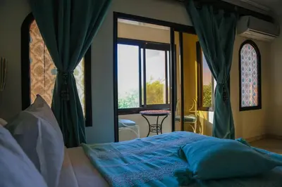 a bedroom with a bed and a window and a table at Villa Eden Marrakech - Luxury Spa Events in Douar bel Rhanodour