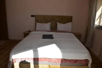 a bedroom with a large white bed with a headboard at Appartement Laaz in Midelt