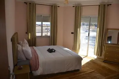 a bedroom with a bed and a large window at Appartement Laaz in Midelt