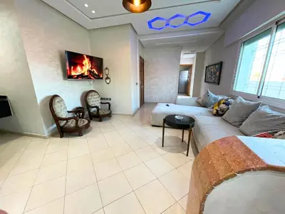 a living room with a couch and a fireplace at 2BR apartment - City Center Residency - Panoramic City Views - 3 Min Train Access by ZenStay in Fès