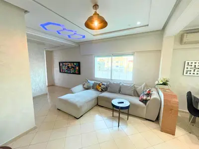 a living room with a couch and a table at 2BR apartment - City Center Residency - Panoramic City Views - 3 Min Train Access by ZenStay in Fès