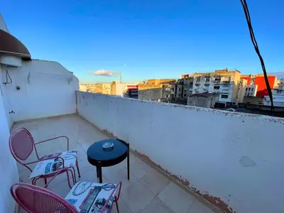 a patio with chairs and a table on a balcony at 2BR apartment - City Center Residency - Panoramic City Views - 3 Min Train Access by ZenStay in Fès