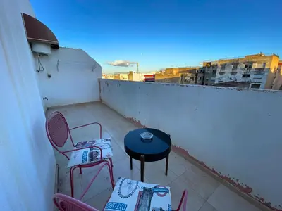 a patio with chairs and a table on a balcony at 2BR apartment - City Center Residency - Panoramic City Views - 3 Min Train Access by ZenStay in Fès