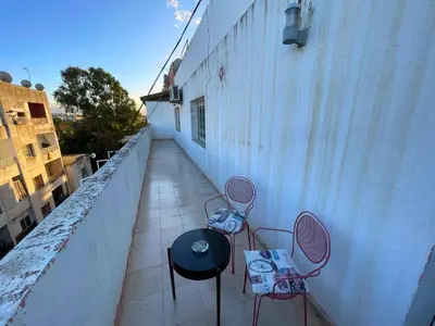 a patio with two chairs and a table on a balcony at 2BR apartment - City Center Residency - Panoramic City Views - 3 Min Train Access by ZenStay in Fès
