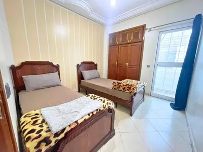 a room with two beds in a room with a window at 2BR apartment - City Center Residency - Panoramic City Views - 3 Min Train Access by ZenStay in Fès