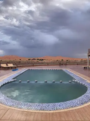 a large swimming pool with chairs in the middle at Kasbah Hôtel Rama in Merzouga