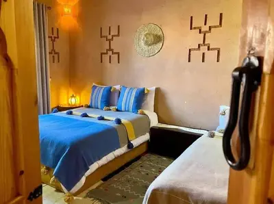 a bedroom with a bed with blue sheets at Dar fatima in Midelt