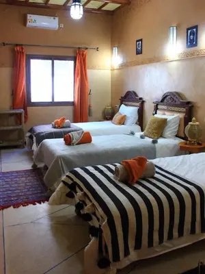 a bedroom with three beds with stuffed animals on them at Dar fatima in Midelt