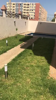 a grassy yard with a swimming pool on a building at Atlas stay in Fès