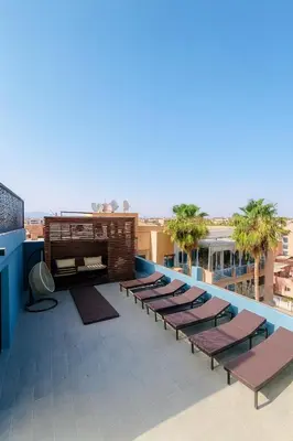 a row of chaise lounges on the roof of a building at Duplex 3 chambres - Piscine & Gym à 5 min du Carre Eden - Marrakech Center in Oulad Akkou